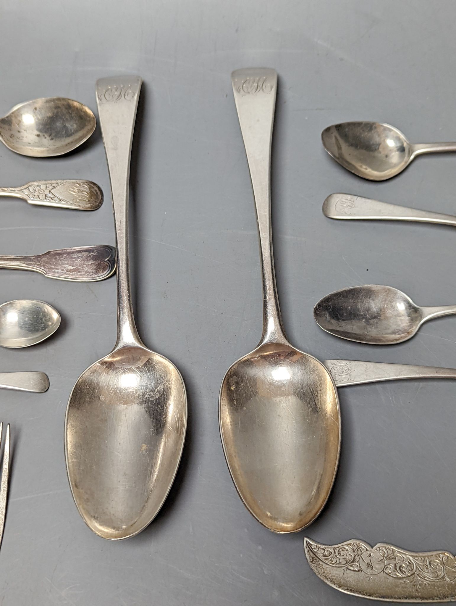 A small quantity of assorted mainly 19th century silver flatware including a pair of George III Old English pattern table spoons, Smith & Hayter, London, 1794 and a silver butter knife, 15oz